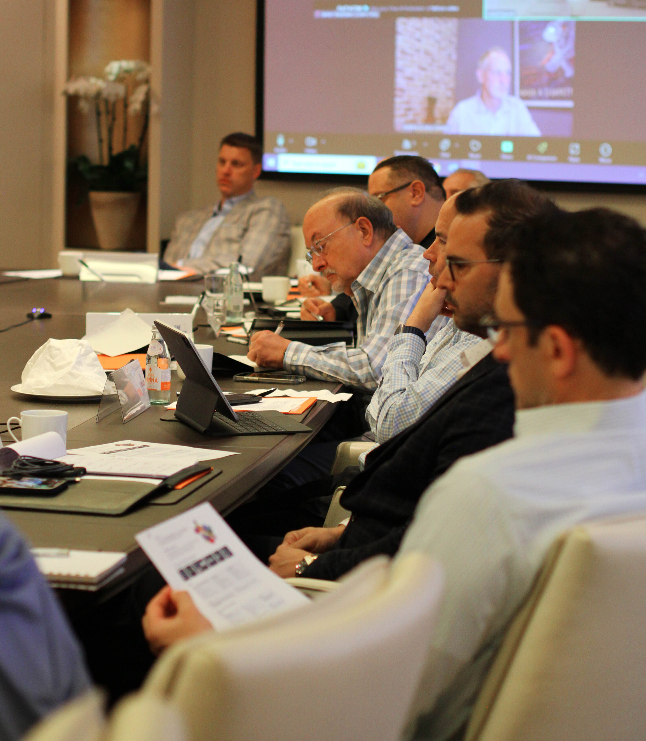 Group of men sitting at a table reviewing presentation notes